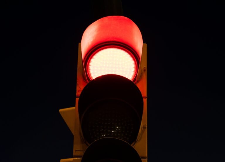 red light on a traffic light at the street at night